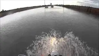Riding motorcycle through flood water.