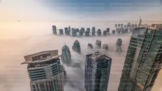 Rare early morning winter fog above the Dubai Marina skyline and skyscrapers rooftops aerial