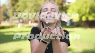 Teenager girl blows multicolored confetti from her hands.