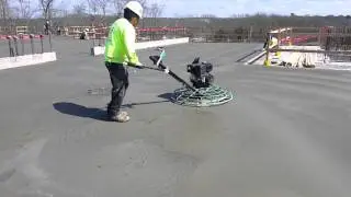 Finishing a concrete floor using a 4 foot walk-behind power trowel.