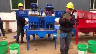 Los trabajadores operan la máquina de ladrillos Hydraform M7M1 para producir ladrillos Hydraform.