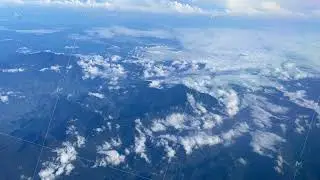 flying over andes mountain, view from the airplane window, amateur video, blue sky and clouds
