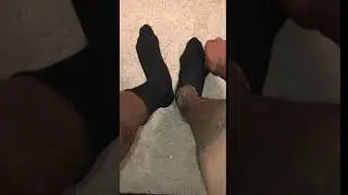 Will removes his black socks slowly from his size 17 US feet, and wiggling, flexing his long toes