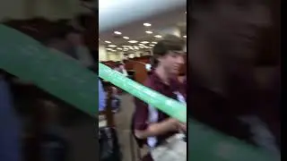 Guy shoots off a balloon in a school library.