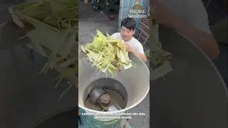 A man uses a small feed grinder to process corn cobs, husks, and hay into animal feed...