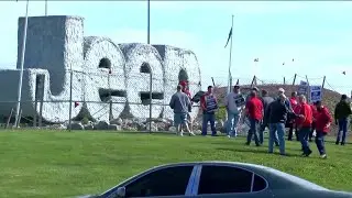 Workers strike at all 3 Detroit automakers, a new tactic to squeeze companies for better pay