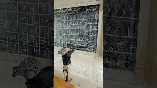A little boy reading Sindhi alphabet