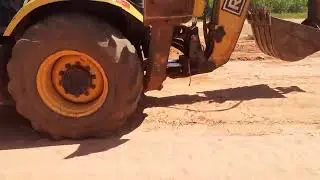 Largato saindo de baixo da m&aacute;quina retroescavadeira 