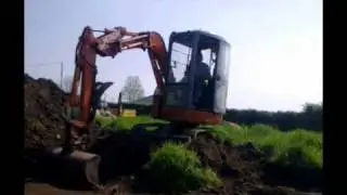 mini digger pilling topsoil  22.5.10.wmv