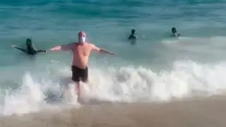Guy swimming in ocean with mask at beach COVID social distancing