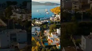 Vertical video. Bodrum, Turkey. Aerial drone panorama of white houses on slopes overlooking Gokov...