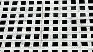 Unfinished residential building facade in Moscow showing repetitive empty window frames