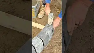 Worker Installing Curved Stone Blocks Using Rubber Mallet