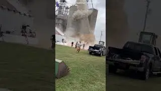 workers running as a grain bin elevator collapsed