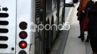 Public bus stopping, people boarding and alighting