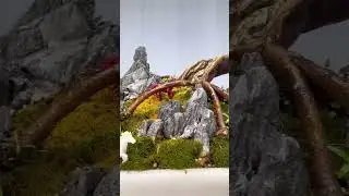 Landscape bonsai filled with mountains, rocks, water, and figures