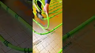 Securing green heating tube onto grid-marked insulation sheet