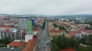 Aerial views capture Brno city center, showcasing cars and trams moving along a busy road amidst