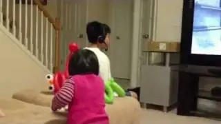 Caryn is feeding her bro while he's busy playing games