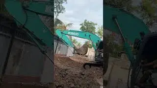Excavator hits concrete with wooden poles,Excavator tractor digging pits