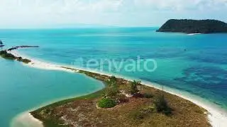 Shoreline of tropical island with narrow stripe of sandy beach entering on calm turquoise lagoon, Th