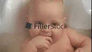 A closeup of an adorable baby girl smiling in bathtub