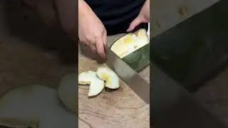 The process of cutting papaya fruit using a sharp knife by a chef