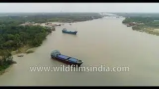 Cargo boats sailing across the Hatania-Doyania River, West Bengal, India