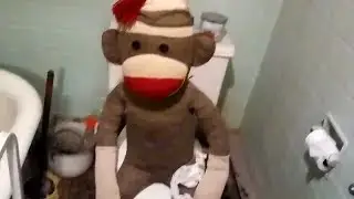 Jumbo Sock Monkey Sitting On The Toilet