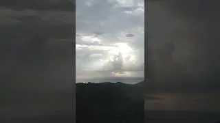 Sunlight Breaking Through Clouds Over Mountains | Drone Shot