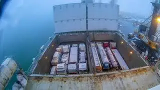 Zeitraffer vom Beladen eines Schiffes mit LKWs