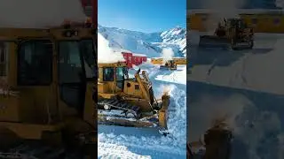 Bulldozers clearing snow around frozen mountain camps.