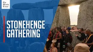 Crowds celebrate the sunrise at Stonehenge for summer solstice