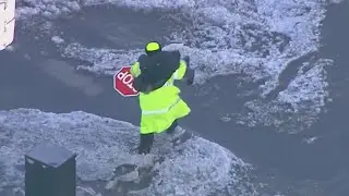 Watch as crossing guard carries child across flooded Chicago street