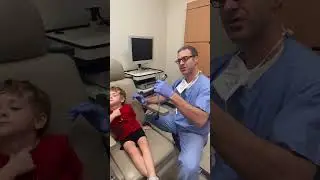 How should you hold an otoscope?