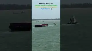 A small tugboat towing a massive barge.