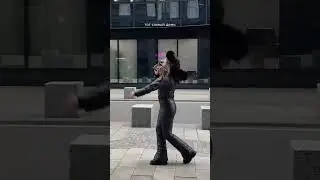 A CHERRY GIRL DANCING IN A BLACK SHINY SKI SUIT WITH A HOOD.