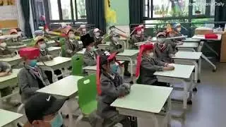 Chinese children wear 'one-metre hats' to keep distance in class