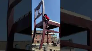 SPIDERMOE CLIMBING THE BIG CHAIR IN ANACOSTIA SE DC