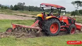 Tractor plowing rice fields in water