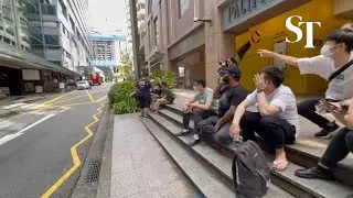Kitchen staff seated opposite of Shaw Centre after a kitchen fire broke out on Nov 22, 2021.
