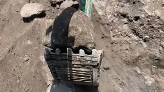 Sand mining indonesia, heavy equipment works extra hard to dig sand between large rocks
