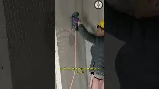 Workers install steel wire mesh on indoor walls and then plaster them with concrete
