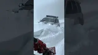 Jeep plowing through snow over the hood with tracks