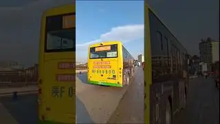 A yellow Yutong electric city bus crossing a bridge in a county town in China.宇通新能源电动公交车#ChinaStreet
