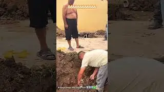 Rural men drilling drainage holes under driveway for their village