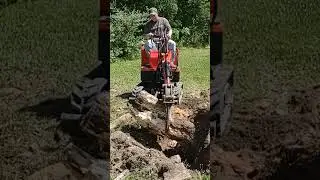 Gardner's Groundhog Mini Excavator lifting a Very Heavy Stump