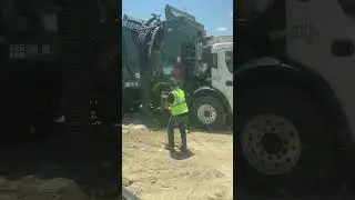 Side Loader Driver Cleaning out Trap Doors