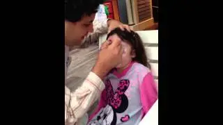Violet gets her face painted like a kitty at Disneyland by