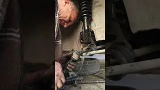 Rustic mechanic dismounting retaining ring in CV joint of old Daewoo Tico during DIY car repairs.